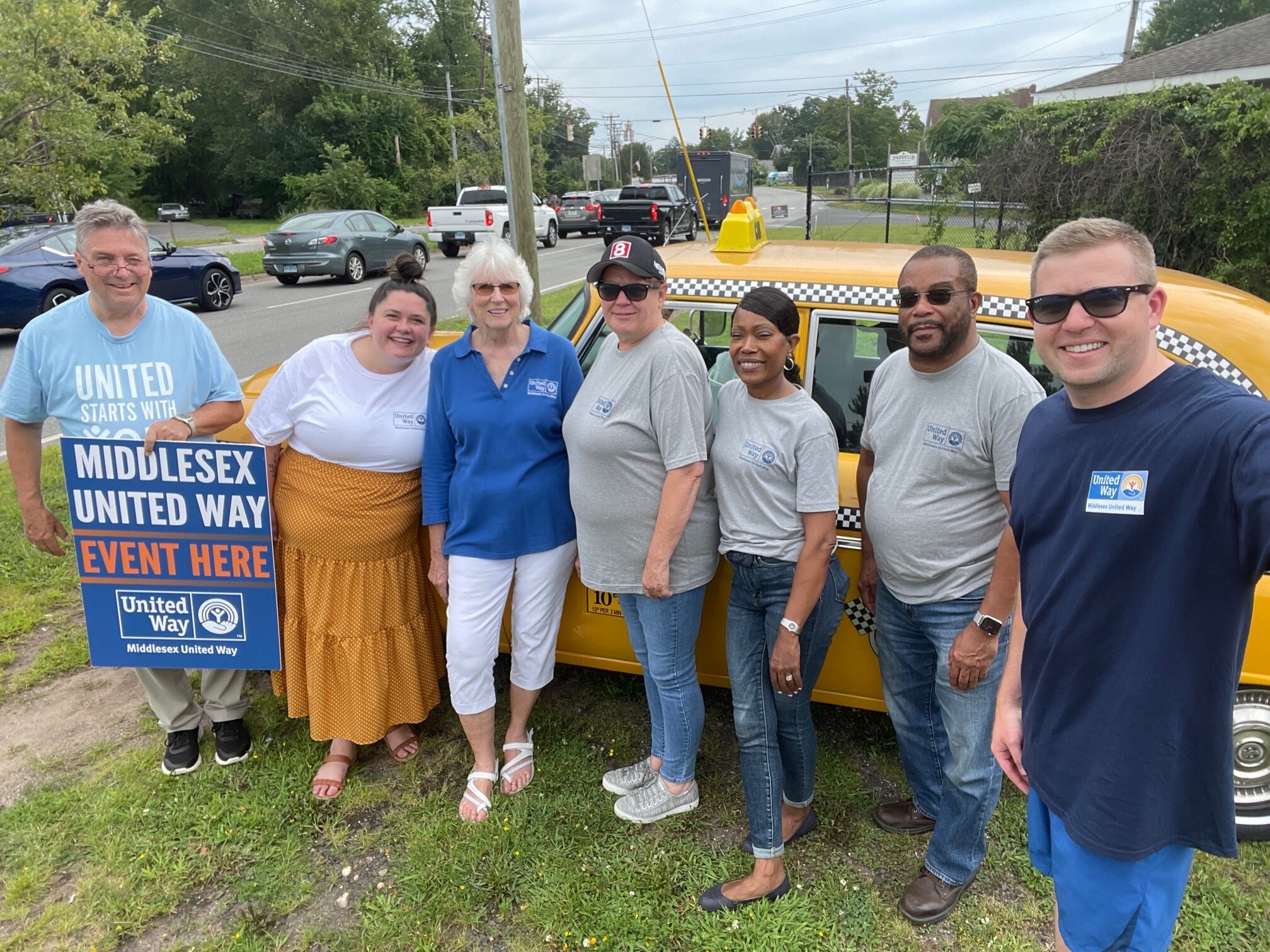 Middlesex United Way staff post for a picture in front of the taxi